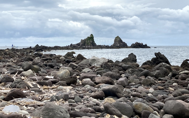 遠くに三ツ石。海岸にはゴミがいっぱい